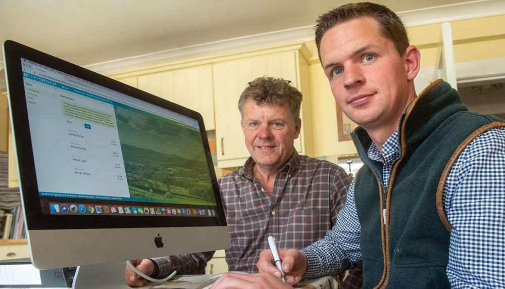 Two farmers using Farmbench on a farm office compute